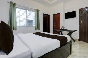 a bedroom with a bed with a desk and a window at HOTEL O SPACE INN NH 44 in Pānchgaon