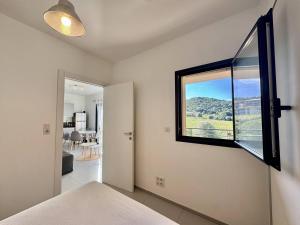 a bedroom with a window and a view of a room at T2 à 200m des plages in Propriano