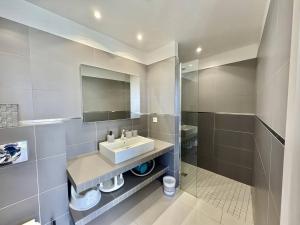 a bathroom with a sink and a mirror and a shower at T2 à 200m des plages in Propriano