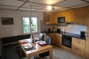 a kitchen with a wooden table and a dining room at theBlackwood in Todtnauberg