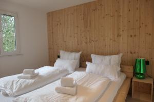 a bedroom with two beds with white sheets and a window at theBlackwood in Todtnauberg