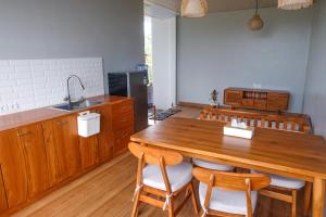 a kitchen with a large wooden table and chairs at Loka Shanti Mas in Mantaak