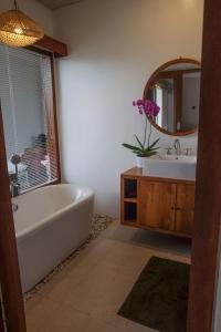 a bathroom with a tub and a sink and a mirror at Loka Shanti Mas in Mantaak