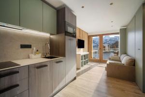 a kitchen with a sink and a couch in a room at Résidence Freddie in Tignes