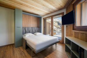 a bedroom with a bed and a large window at Résidence Freddie in Tignes