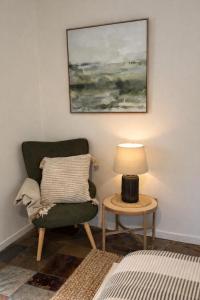a living room with a green chair and a table at Private Rainforest Guesthouse in Doonan in Doonan