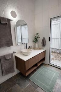 a bathroom with two sinks and a mirror at Private Rainforest Guesthouse in Doonan in Doonan