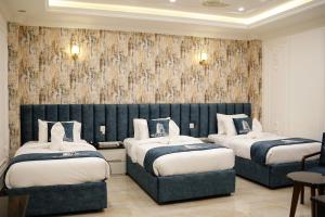 a hotel room with two beds and a wall mural at Skyline Hotel in Sargodha +26 photos