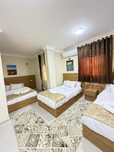 a hotel room with three beds in a room at Siwa Star Rooms in Siwa