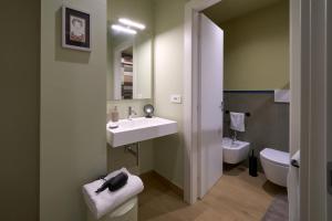a bathroom with a sink and a toilet at Merlino Urban Suites in Messina