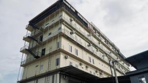 a tall white building with a lot of windows at Kara Guest House AA1 in Batam Center