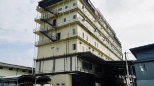 a tall white building with scaffolding on the side of it at Kara Guest House AA1 in Batam Center