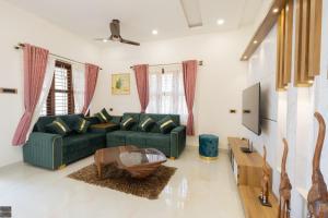 a living room with a green couch and a table at Reunion Ocean Hridayam - Beach House in Udupi