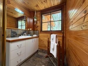 a bathroom with a sink and a mirror at Springbrook Mountain Chalets in Springbrook +69 photos