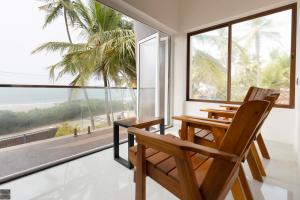 a dining room with two chairs and a table with a view of the ocean at Reunion Ocean Hridayam - Beach House in Udupi