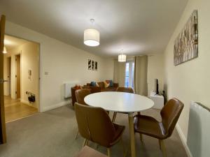 a dining room and living room with a table and chairs at Wokingham Stylish Two Bedroom Apartment in Wokingham