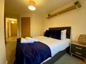 a bedroom with two beds with blue and white sheets at Wokingham Stylish Two Bedroom Apartment in Wokingham
