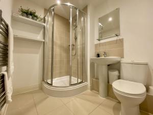 a bathroom with a shower and a toilet and a sink at Wokingham Stylish Two Bedroom Apartment in Wokingham