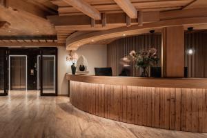 a hotel lobby with a reception counter and flowers at VAYA Lechtal in Elbigenalp