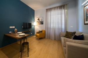 a living room with a couch and a table at Merlino Urban Suites in Messina
