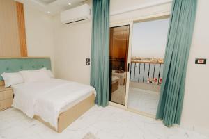 a bedroom with a bed and a large window at ElMena House Luxor in Luxor