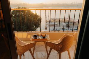 a table and chairs on a balcony with a view at ElMena House Luxor in Luxor