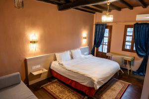 a bedroom with a large bed with blue curtains at Αρχοντικό Παπαγιάννη in Edessa