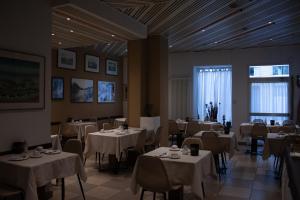 restauracja z białymi stołami i krzesłami oraz oknem w obiekcie HB Lugano w mieście Lugano