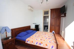 a bedroom with a bed with blue sheets and a television at Apartments Nensy in Bar +40 photos