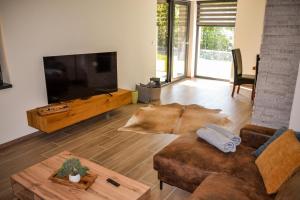 a living room with a couch and a flat screen tv at Chata Zingoty in Mýto pod Ďumbierom