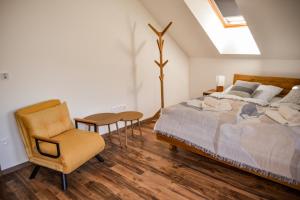 a bedroom with a bed and a chair at Chata Zingoty in Mýto pod Ďumbierom