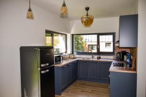 a kitchen with blue cabinets and a black refrigerator at Chata Zingoty in Mýto pod Ďumbierom