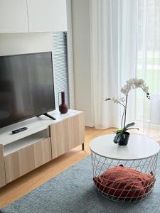 a living room with a television and a coffee table at Haga Home in Tallinn +3 photos