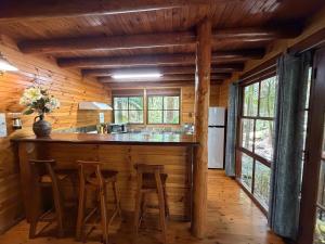 a kitchen with a bar in a log cabin at Springbrook Mountain Chalets in Springbrook