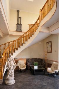 a living room with a staircase with a statue at Hotel Trajano in Zalamea de la Serena