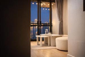 a living room with a table and a large window at AimeeHouse - Trích Sài in Hanoi