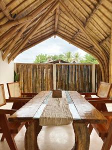 a wooden table with chairs and a wooden ceiling at Sea Turtle Villas in Gili Islands
