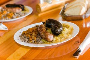 a plate of food with sausages and rice on a table at EkoTurizem Viženčar in Cerklje na Gorenjskem