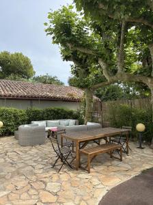 a patio with a table and chairs and a tree at Maison au coeur de Guéthary in Guéthary