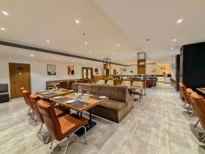 a restaurant with a couch and tables and chairs at Zip By Spree Hotels Chakan, Pune in Pune