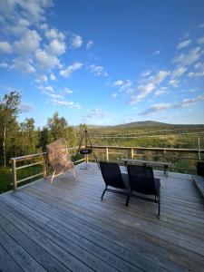 a deck with two chairs and a table on it at Camp Oinas in Hammerfest