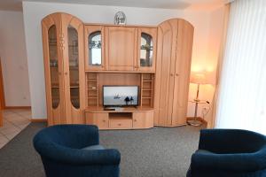 a living room with a tv in a wooden cabinet at Bernstein Mare-Supreme Wohnung 4 in Büsum