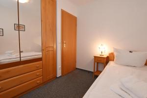 a bedroom with a bed and a sink and a mirror at Bernstein Mare-Supreme Wohnung 4 in Büsum +2 photos