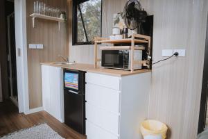 a kitchen with a microwave on top of a counter at Pigeon Pair Tiny Houses by Tiny Away in Tallarook