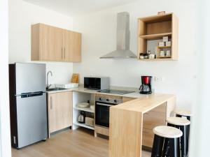 a small kitchen with a refrigerator and a counter at Friendly & Warm in Tamarin