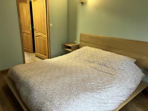 a bedroom with a bed with a wooden head board at La Pause Normande - Bed & Breakfast in Bayeux