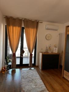 a living room with curtains and a large window at Stadium Central Apartment Residence & terrace in Craiova