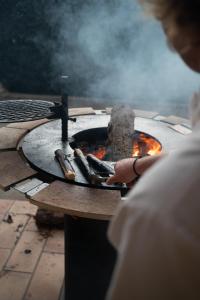 a person is cooking food in an outdoor oven at Villa Liberty in Entraigues-sur-la-Sorgue