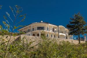 a white building on top of a stone wall at Pansion Preza in Selce