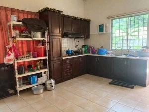 a kitchen with wooden cabinets and a counter top at SemiD in Batu Kikir